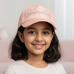 Charger l'image dans la galerie, Young girl wearing a pink cap with 'Mermazing' text, sitting on a pink couch.