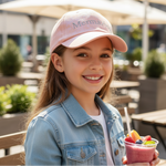 Charger l'image dans la galerie, Young girl wearing a pink cap with 'Mermaid' text, holding a colorful smoothie outdoors.