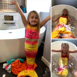 Load image into Gallery viewer, Young child wears the Yellow & Pink Mermaid Tail in the tub. Matching material tankini that looks great as a crop top with jean shorts. Part of our more affordable range, this tail has poppers at the bottom. The monofin can be taken on and off easily without stepping out of the whole tail. Mini Mermaid Tails