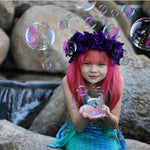 Load image into Gallery viewer, Sweet little girl mermaid with red hair and purple flowers on her head, holding bubbles and wearing the Ocean Blue double frill bikini with matching vibrant mermaid tail. Part of our luxury range, this tail has a high quality side zip. Mini Mermaid Tails