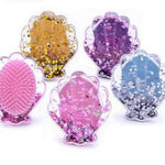 Load image into Gallery viewer, Super Cute, sparkly glitter seashell detangling hairbrush. Shake and wake up the dreamy undersea world and watch the fascinating glitter. Available in gold, purple, blue, or pink. Mini Mermaid Tails