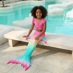 Load image into Gallery viewer, Coco wearing the Paradise mermaid tail and pink tankini beside a pool