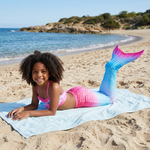 Load image into Gallery viewer, Coco wearing the Pink and Blue mermaid tail and matching halter top, resting on a beach towel