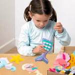 Load image into Gallery viewer, A child sews a very cute mermaid tail with her adorable Felt Sewing Kit wit adorable Mermaid, Mermaid tail, Clam Shell, Seahorse, and Starfish patterns. It comes with pre-cut shaped felts, safety scissors, plastic sewing needles, a batch of cotton, and embroidery threads. Mini Mermaid Tails
