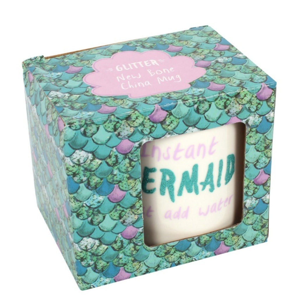 Bone china mug for adult mermaids, white with teal handle, says "Instant Mermaid (in teal colored glitter) just add water" with pink lettering in box. Mini Mermaid Tails