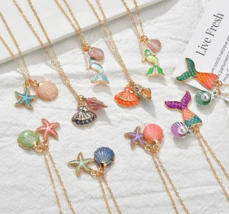 Pretty enamel mermaid inspired necklaces. Each one has its own intricate charm and are loved by all mini mermaids and adults alike.  Shells, starfish, mermaids and mermaid tails in different colors makes these necklaces beautiful. Mini Mermaid Tails