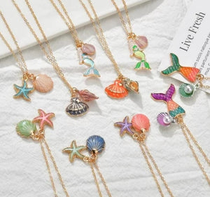 Pretty enamel mermaid inspired necklaces. Each one has its own intricate charm and are loved by all mini mermaids and adults alike.  Shells, starfish, mermaids and mermaid tails in different colors makes these necklaces beautiful. Mini Mermaid Tails