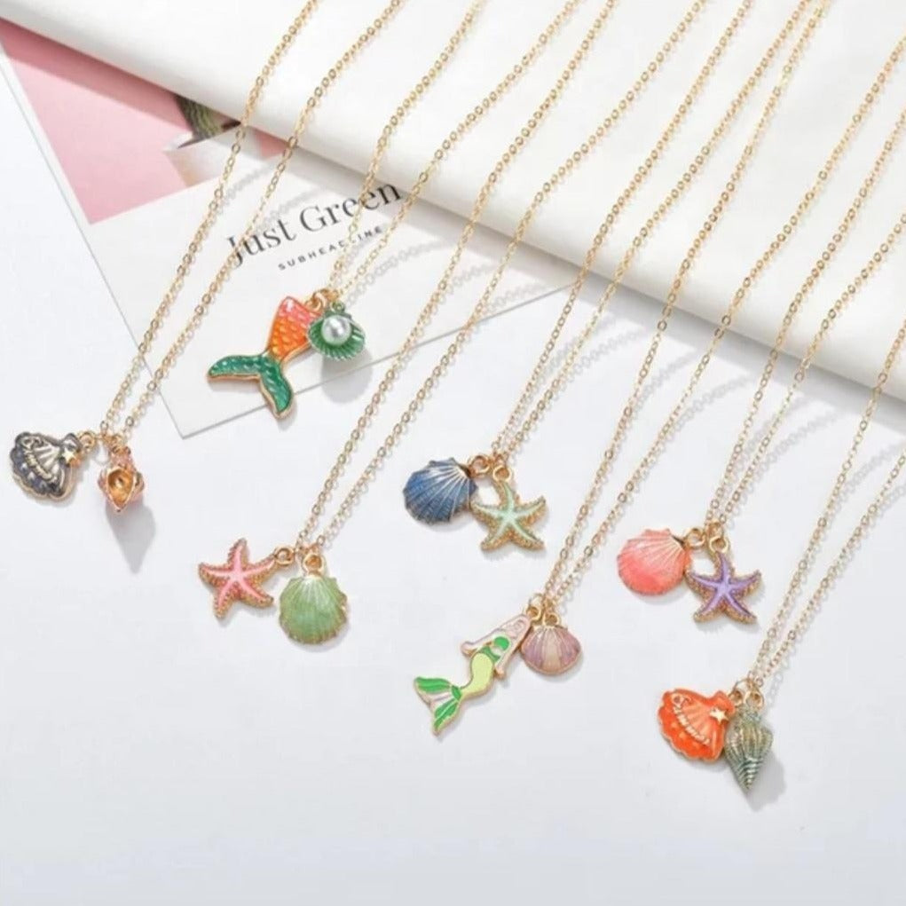 Assortment of beautiful necklaces including charms depicting mermaids, different shells, starfish and mermaid tails with a pearl for kids. Mini Mermaid Tails 