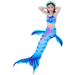 Smiling girl wearing Bold Blue Tiger Mermaid Tail with just a splash of purple. Complete with dorsal fins for a true little mermaid look and matching material halterneck bikini with cute embellished bow and blue flowers in her hair. Mini Mermaid Tails