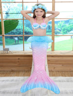 Load image into Gallery viewer, Smiling girl wearing the intricate, slightly padded shell like bikini top with a printed pearl mermaid tail with a netted peplum.  This tail has no fastenings at the bottom so the monofin can be taken on and off easily without stepping out of the whole tail. Mini Mermaid Tails

