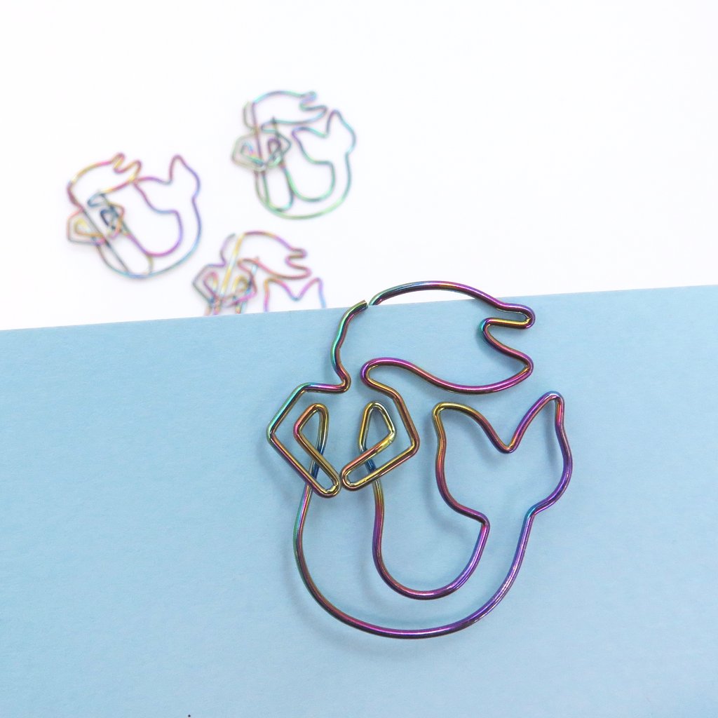 Rainbow colored Mermaid Paperclip shown clipped to blue paper. Mini Mermaid Tails