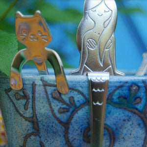 Silver stainless steel Mermaid Tea Spoon in a cup next to a cute little cat spoon. Mini Mermaid Tails