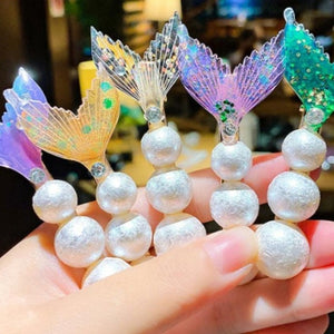 A picture of someone holding adorable Mermaid Tail Beach Hair Clips in different pastel colors. Mini Mermaid Tails