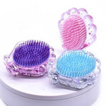 Load image into Gallery viewer, Photo shows the hairbrush side of the sparkly glitter seashell detangling hairbrushes in pink, purple, and blue. Gold also available. Mini Mermaid Tails
